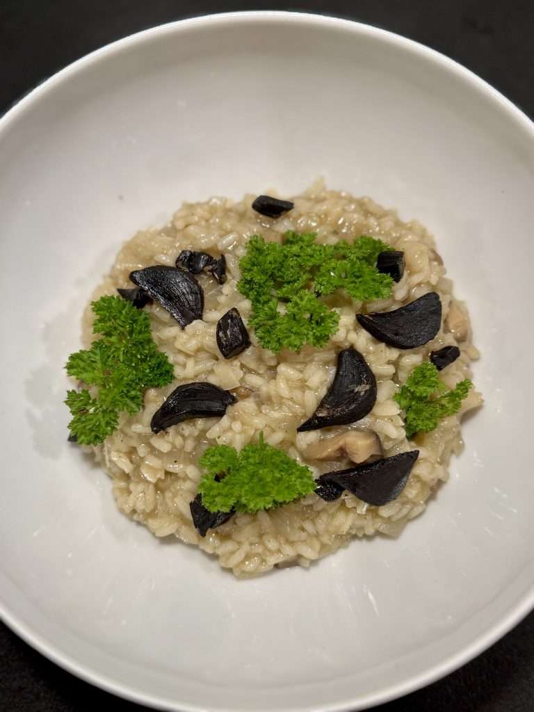 Idée recette de risotto aux champignons servi avec de l'ail noir