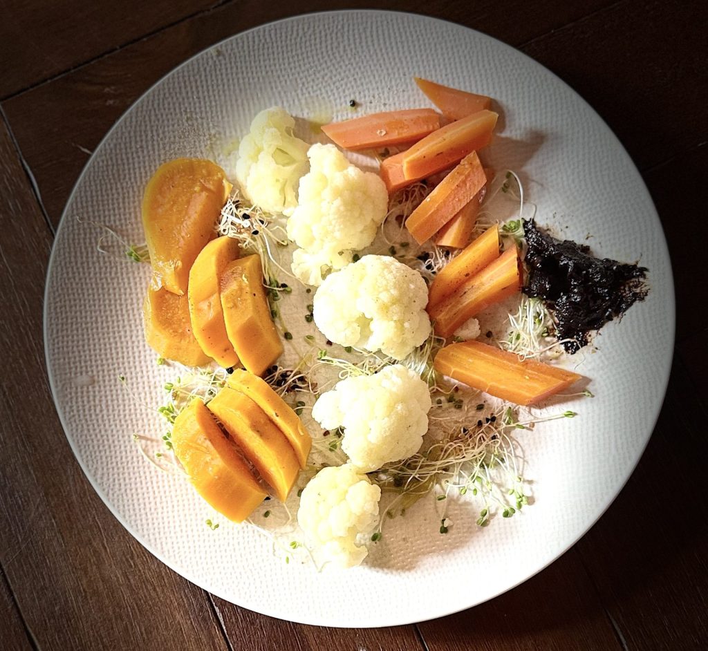 Idée recette avec une assiette de legumes vapeur avec de la crème d'ail noir
